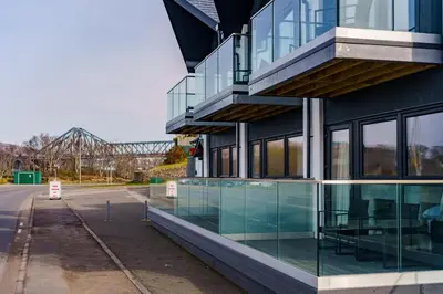 a glass facade of a building with a bridge in the background at Oyster Inn Connel in Oban