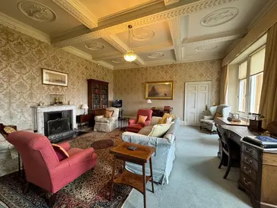 a living room filled with furniture and a fireplace at The South Wing in Acharn