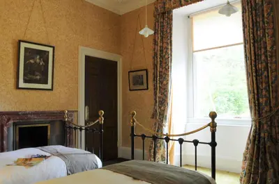 a bedroom with two beds and a window at The South Wing in Acharn