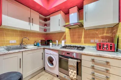 a kitchen with a sink and a washing machine at Edinburgh Drumdryan Central Apart in Edinburgh
