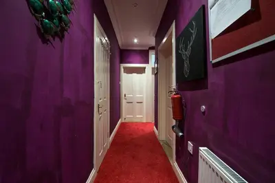 a hallway with purple walls and a red carpet at Edinburgh Drumdryan Central Apart in Edinburgh