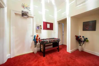 a room with a red carpet and a table with flowers at Edinburgh Central Morrison Apartment in Edinburgh