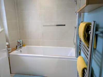 a bathroom with a white bath tub in a room at Edinburgh Home from Home in Edinburgh