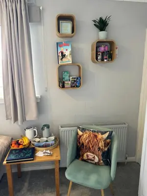 a room with a table and a chair with a pillow at Edinburgh Home from Home in Edinburgh