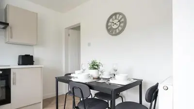 a dining room table with chairs and a clock on the wall at Craigseaton House in Broxburn