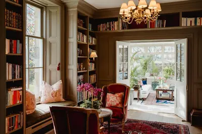 a library with bookshelves and a table and chairs at Private and Prestigious Luxury Home in Edinburgh
