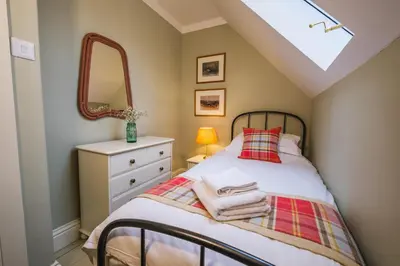 a bedroom with a bed with a mirror and a dresser at Craigendarroch No 1 in Acharn