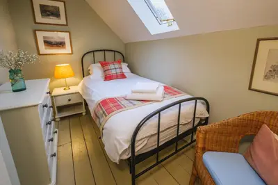 a small bedroom with a bed and a lamp at Craigendarroch No 1 in Acharn