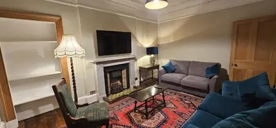 a living room with a couch and a fireplace at Cosy 2 bedroom flat-castle view in Edinburgh