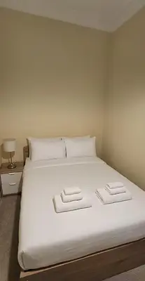 a large white bed with two folded towels on it at Cosy 2 bedroom flat-castle view in Edinburgh