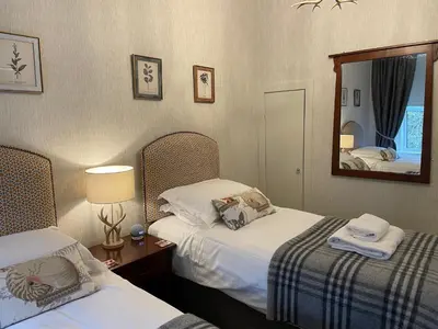 a hotel room with two beds and a mirror at The Shore House in Lochgoilhead