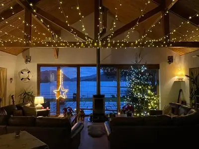 a living room with a christmas tree and lights at The Shore House in Lochgoilhead