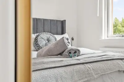 a bedroom with a bed with a mirror on it at Ochil View 30 mins to Edinburgh and Glasgow in Falkirk