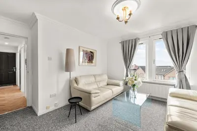 a living room with a couch and a glass table at Ochil View 30 mins to Edinburgh and Glasgow in Falkirk