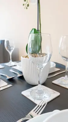 a table with wine glasses and a vase on it at Forbes House in Glasgow