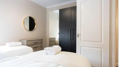 a bedroom with two beds and a mirror at Forbes House in Glasgow