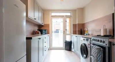 a kitchen with a refrigerator and a washer and dryer at Tummel Place in Grangemouth