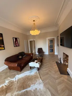 a living room with leather furniture and a chandelier at Spacious 2 Bed Edinburgh - Perfect Location in Edinburgh
