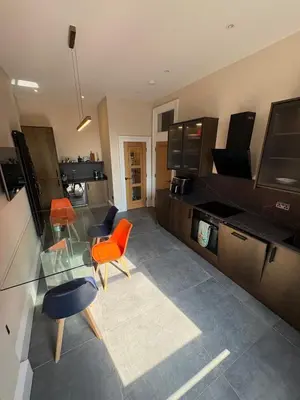 a living room with a glass table and orange chairs at Spacious 2 Bed Edinburgh - Perfect Location in Edinburgh