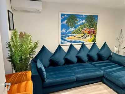 a blue couch in a living room with a painting at Middle Kent Lux! in Moffat