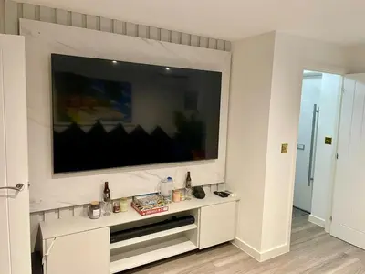 a living room with a large flat screen tv on a wall at Middle Kent Lux! in Moffat