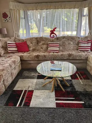 a living room with a couch and a glass table at 27 Glenfinart Caravan Park in Dunoon