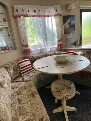 a living room with a table and a couch at 27 Glenfinart Caravan Park in Dunoon