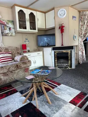 a living room with a coffee table and a fireplace at 27 Glenfinart Caravan Park in Dunoon