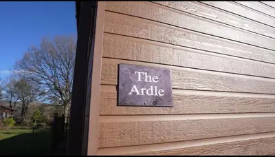 a sign on the side of a house at Luxurious Riverside Lodge - 'The Ardle' in Crieff