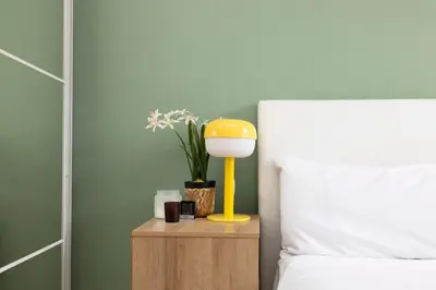 a yellow lamp on a night stand next to a bed at Elegant Apartment in the heart of Edinburgh in Edinburgh