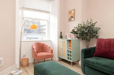 a living room with a green couch and a chair at Elegant Apartment in the heart of Edinburgh in Edinburgh