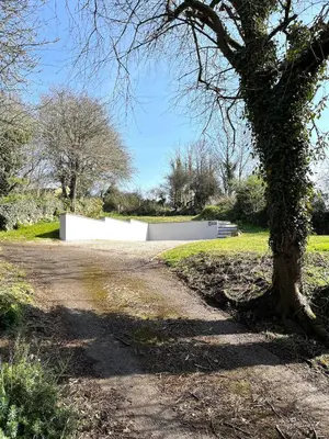 a road with a tree and a white fence at Newly built luxury cabin in Moffat