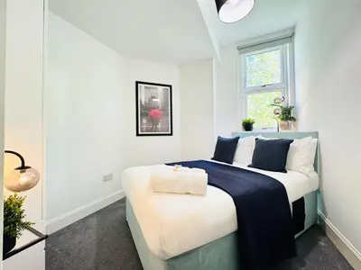 a bedroom with a bed with a blue blanket on it at Cosy City Centre Apartment in Edinburgh