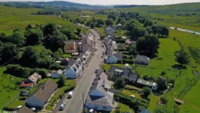 an aerial view of a small village with a road at Granite House in Carsphairn