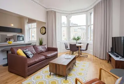 a living room with a couch and a table at Spacious Period Property in Glasgow in Glasgow