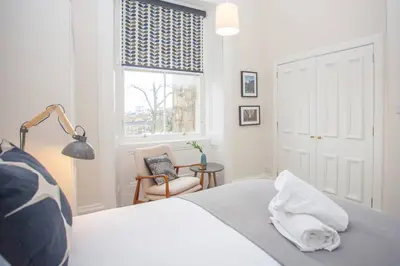 a bedroom with a bed with a dog laying on it at Spacious Period Property in Glasgow in Glasgow