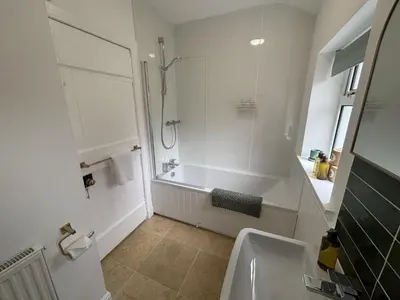 a bathroom with a tub and a shower and a sink at Altchourunn Cottage in Acharra