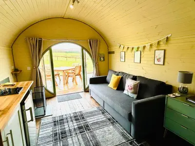 a living room with a couch and a table at Barnharrow Holiday Pods - Rose Glamping Pod with Hot Tub & Fire Pit in Balminnoch