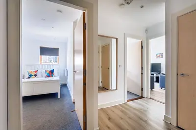 a hallway with a bedroom with a bed and a mirror at Argyle Street Apartments in Glasgow