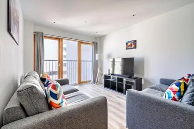 a living room with two couches and a television at Argyle Street Apartments in Glasgow