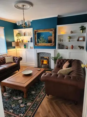 a living room with a couch and a fireplace at The Troon Hoose in Troon