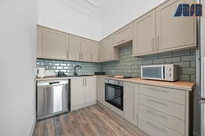 a kitchen with white cabinets and a microwave at Modern 2 Bed Sleep 4 In Gourock in Gourock