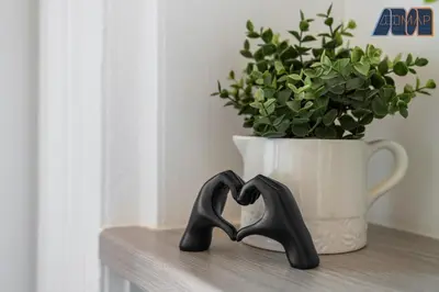 two black heart sculptures sitting on a shelf next to a plant at Modern 2 Bed Sleep 4 In Gourock in Gourock