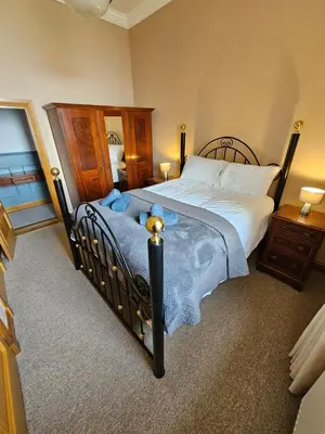 a bedroom with a large bed with a wooden frame at No 8 Lomond Castle in Luss