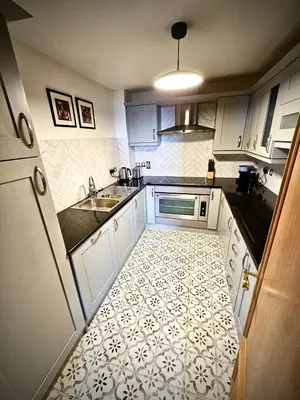 a small kitchen with a sink and a refrigerator at No 8 Lomond Castle in Luss