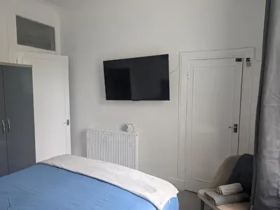 a bedroom with a bed and a tv on the wall at Largs seaside retreat in Largs