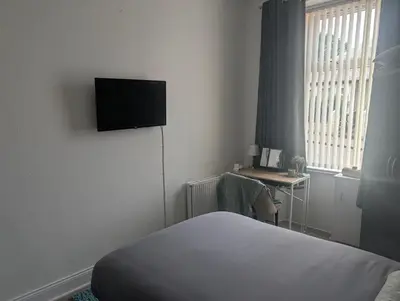 a hotel room with a bed and a television on the wall at Largs seaside retreat in Largs