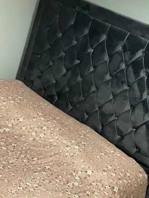 a close up of a bed with a black headboard at Casa da Paz in Glasgow