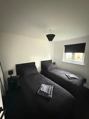 a bedroom with two beds and a window at Home Comfort Prestwick in Prestwick