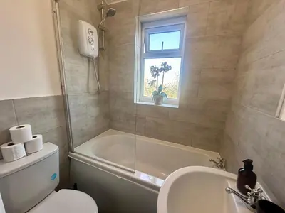 a bathroom with a tub and a toilet and a sink at HULL 2BED Sleeps 4 BETTO Cosy Home! in Moffat